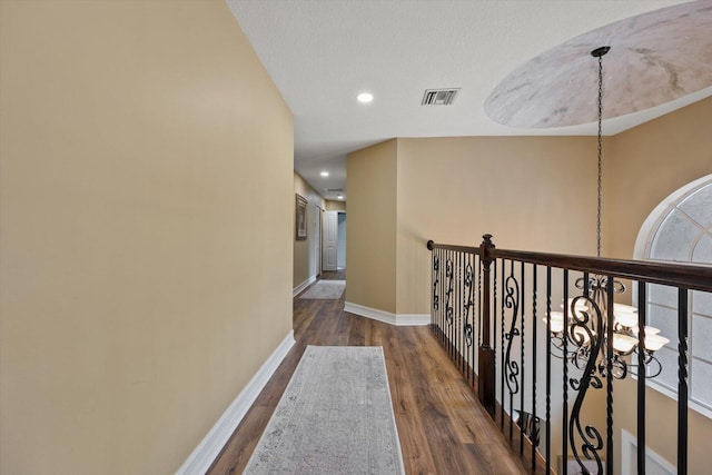 hallway featuring recessed lighting, wood finished floors, visible vents, and baseboards