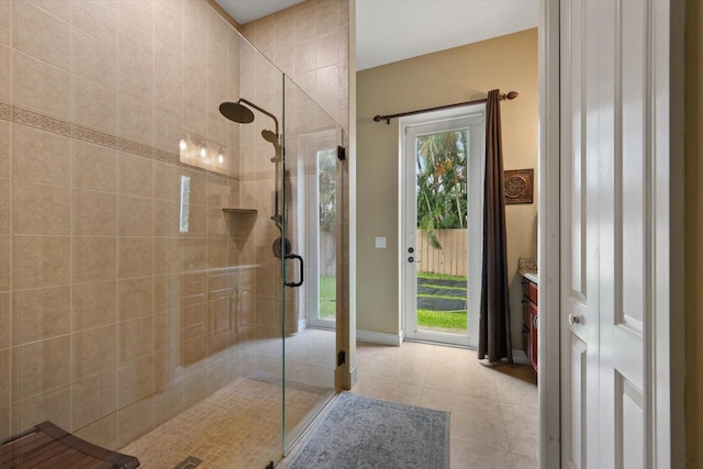 bathroom featuring a stall shower, tile patterned flooring, baseboards, and vanity