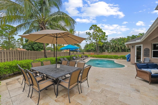 view of swimming pool featuring a patio, outdoor dining area, a fenced backyard, and a fenced in pool