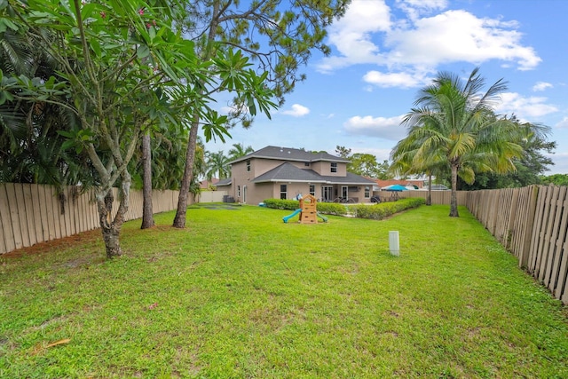 view of yard with a fenced backyard and a playground