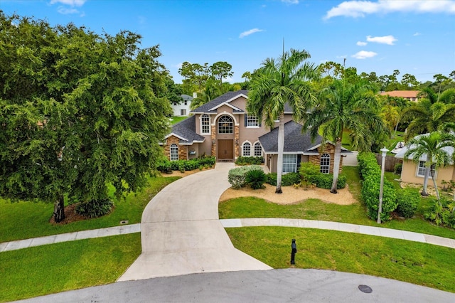 view of front facade featuring driveway and a front yard