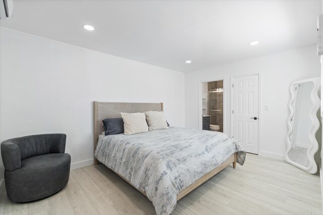 bedroom with light wood-style flooring, recessed lighting, baseboards, and connected bathroom