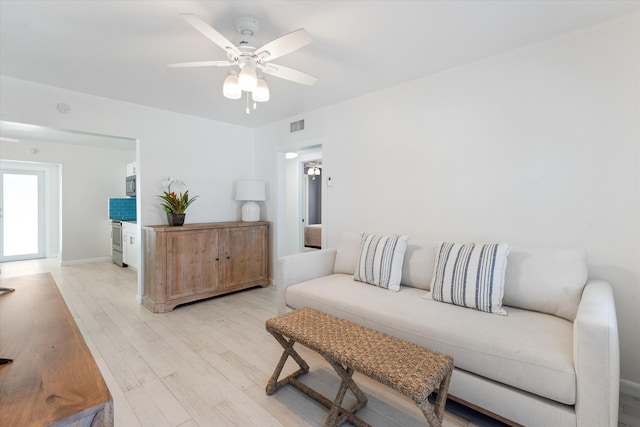 living area featuring visible vents, light wood-style flooring, and ceiling fan