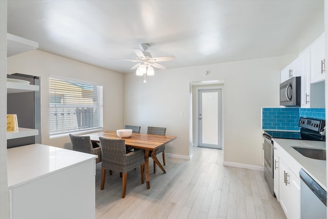 dining room with ceiling fan, light wood-type flooring, and baseboards