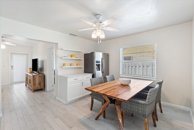 dining room with light wood finished floors, visible vents, baseboards, and a ceiling fan