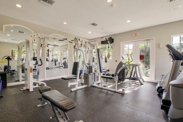 workout area with a textured ceiling, french doors, visible vents, and a healthy amount of sunlight