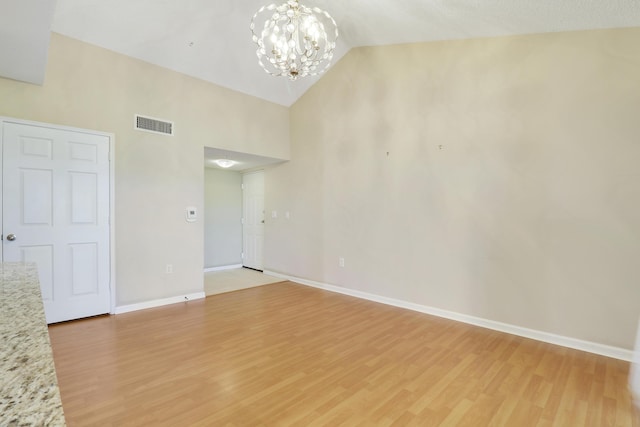 unfurnished room featuring a chandelier, light wood-type flooring, visible vents, and baseboards