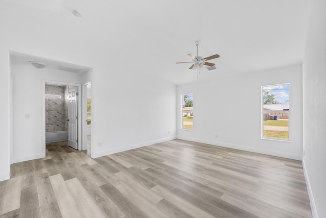 interior space with light wood-style flooring, a ceiling fan, a wealth of natural light, and baseboards