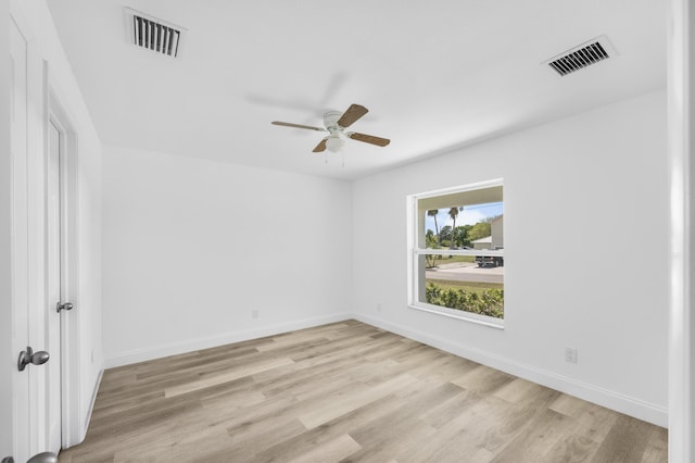 spare room with visible vents, light wood-style flooring, and baseboards