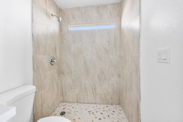 full bath with a tile shower and toilet