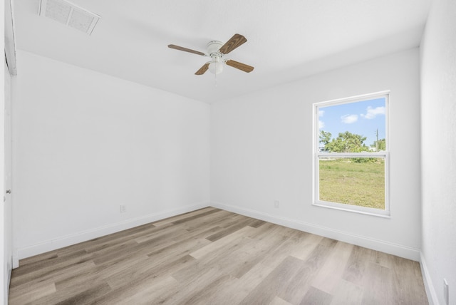 empty room with light wood-type flooring, baseboards, and visible vents