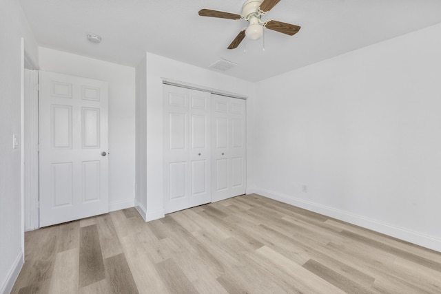 unfurnished bedroom featuring ceiling fan, visible vents, baseboards, a closet, and light wood finished floors