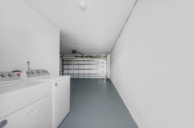 clothes washing area featuring a garage, laundry area, and washer and clothes dryer