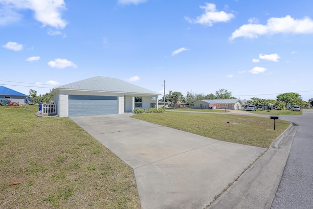 ranch-style home featuring a garage, a front yard, metal roof, and driveway