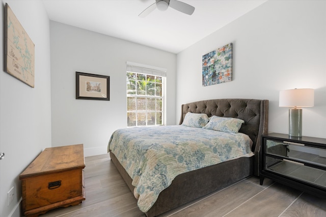 bedroom with ceiling fan, baseboards, and wood finished floors