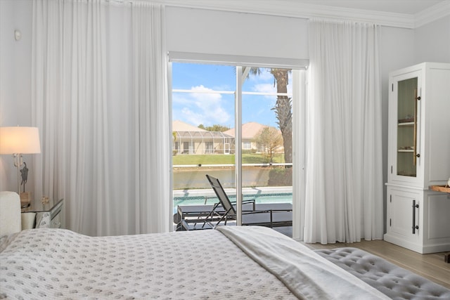 bedroom featuring a water view, access to exterior, and ornamental molding