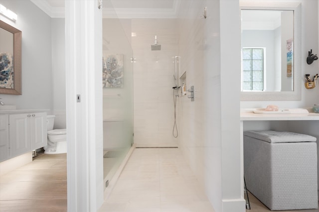 full bathroom featuring vanity, toilet, crown molding, and a walk in shower