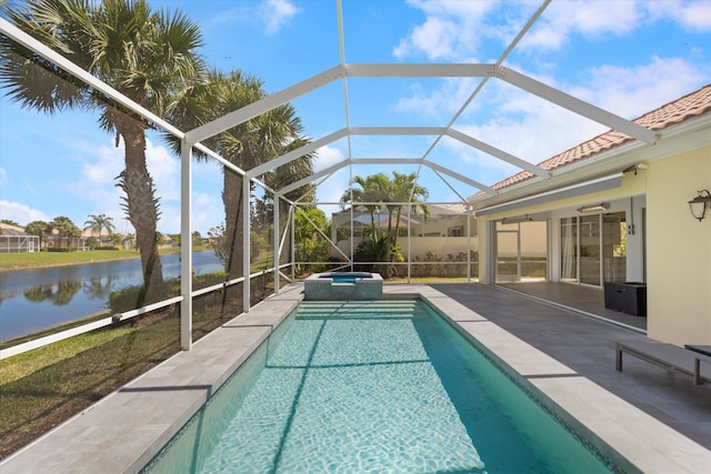 view of swimming pool with glass enclosure, a water view, a pool with connected hot tub, and a patio area