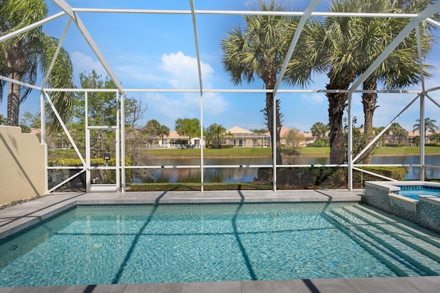 view of pool featuring glass enclosure, a patio, a water view, and a pool with connected hot tub