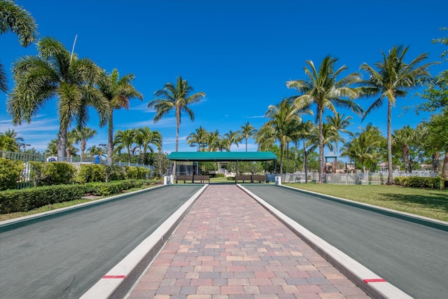 view of road featuring a gated entry and curbs