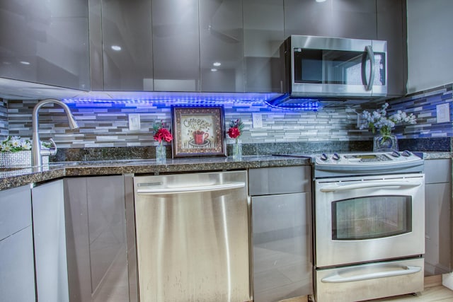 kitchen featuring dark stone counters, backsplash, a sink, and ceiling fan