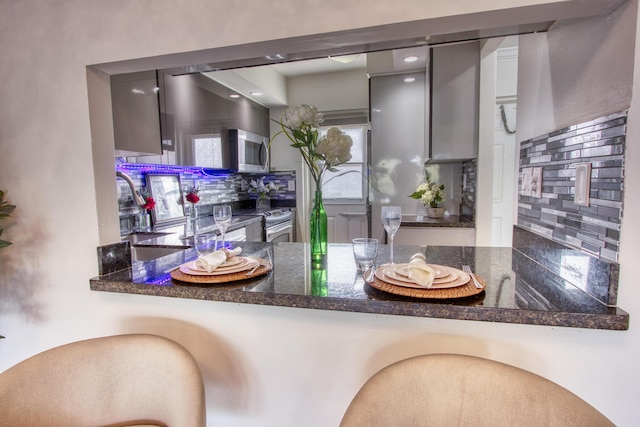 interior space with wood finished floors, baseboards, decorative backsplash, and a sink