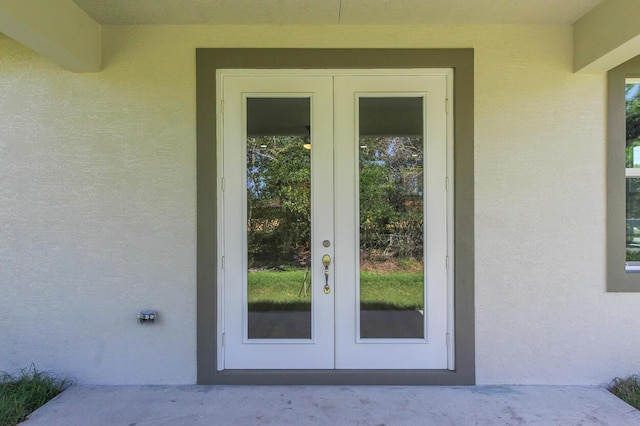 doorway to property featuring french doors and stucco siding