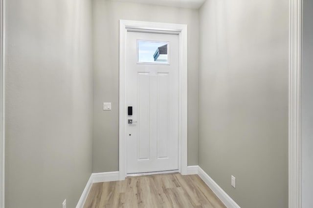 doorway with light wood-style floors and baseboards