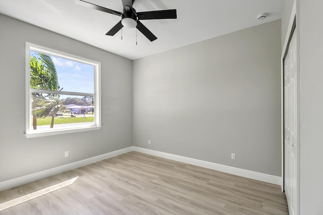 empty room with ceiling fan, baseboards, and light wood-type flooring