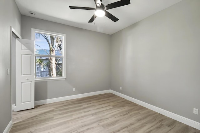 unfurnished room with baseboards, a ceiling fan, and light wood finished floors