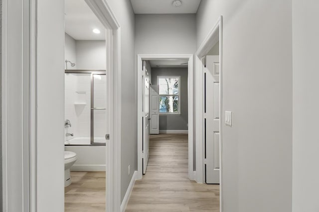 hallway with baseboards and light wood finished floors