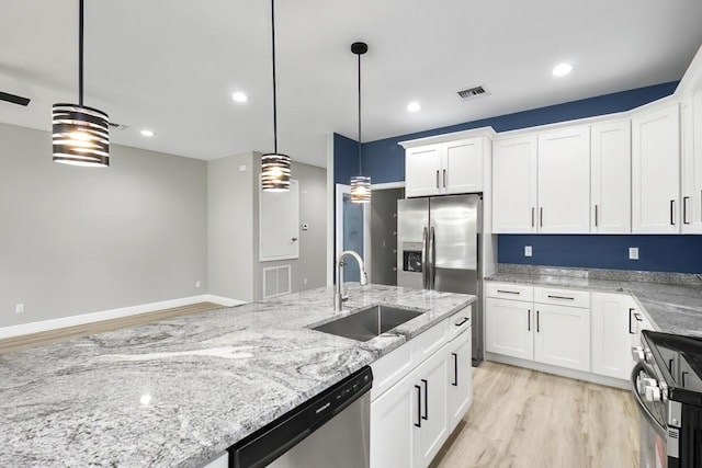 kitchen with light wood finished floors, visible vents, stainless steel appliances, white cabinetry, and a sink