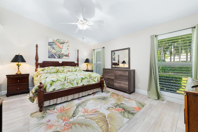 bedroom featuring vaulted ceiling, light wood finished floors, a ceiling fan, and baseboards