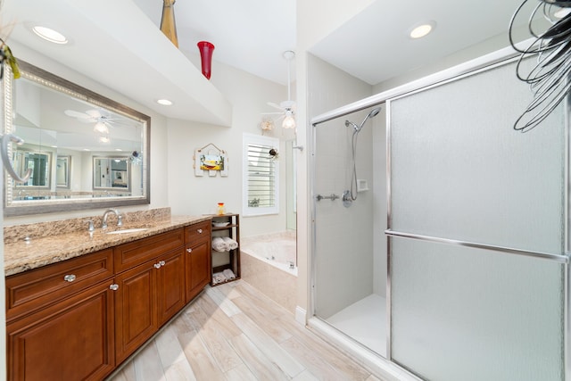 bathroom featuring a garden tub, a shower stall, ceiling fan, and vanity