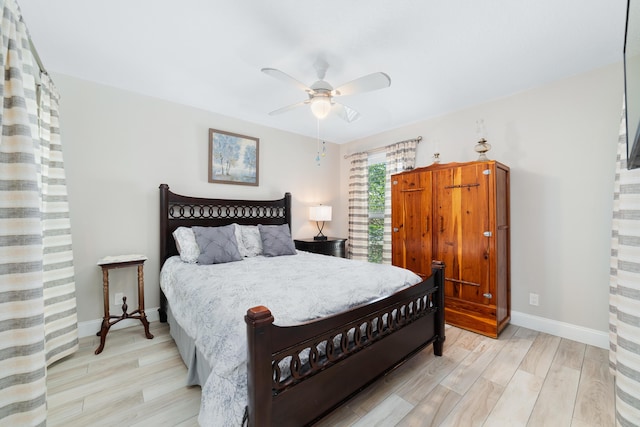 bedroom with a ceiling fan, baseboards, and wood finished floors