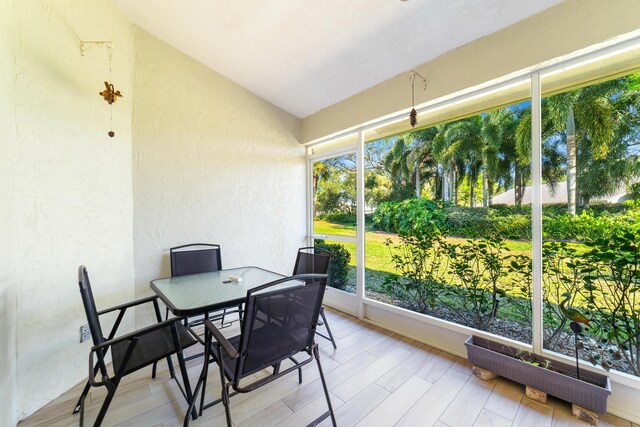 sunroom / solarium with a healthy amount of sunlight, vaulted ceiling, and a ceiling fan