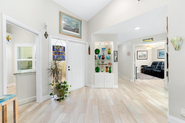 entrance foyer featuring lofted ceiling, light wood finished floors, ceiling fan, and baseboards