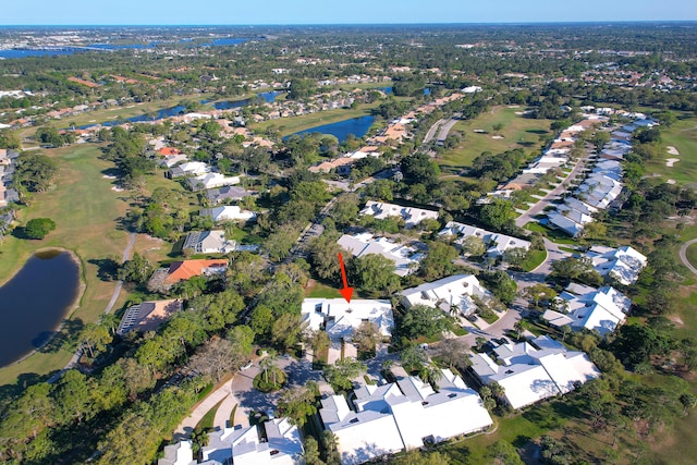 drone / aerial view with view of golf course, a water view, and a residential view