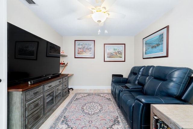 living area featuring light wood-style flooring, visible vents, baseboards, and a ceiling fan