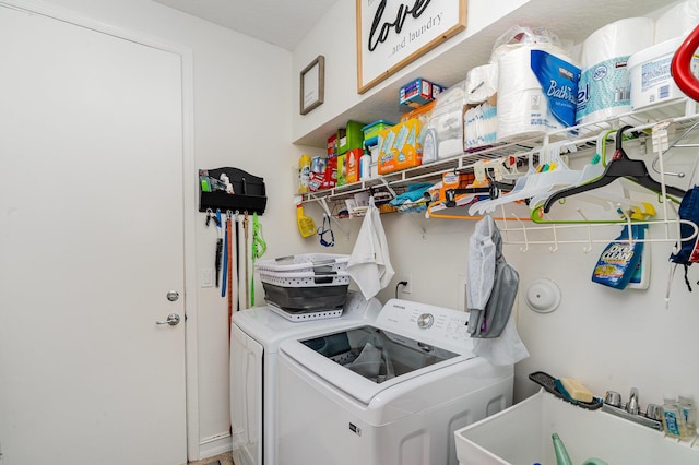 clothes washing area featuring laundry area, separate washer and dryer, and a sink