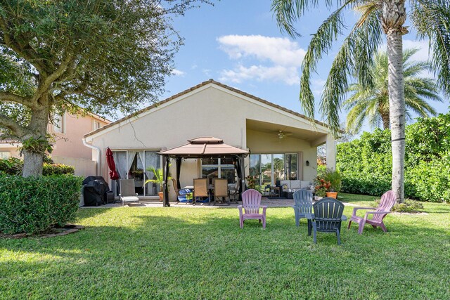 back of house featuring a patio, stucco siding, a lawn, a gazebo, and ceiling fan