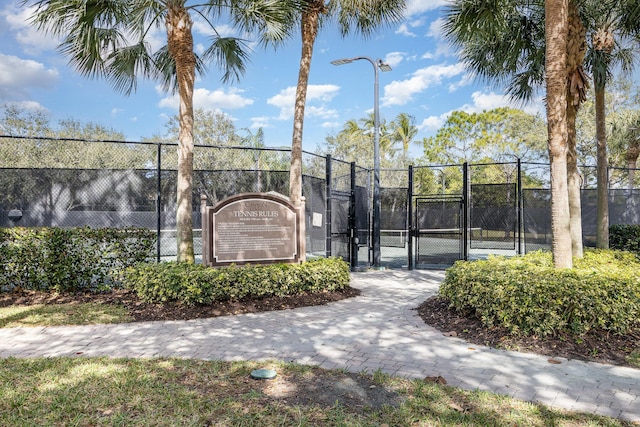 view of tennis court with fence and a gate