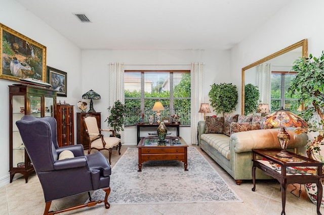 tiled living room featuring visible vents and a healthy amount of sunlight