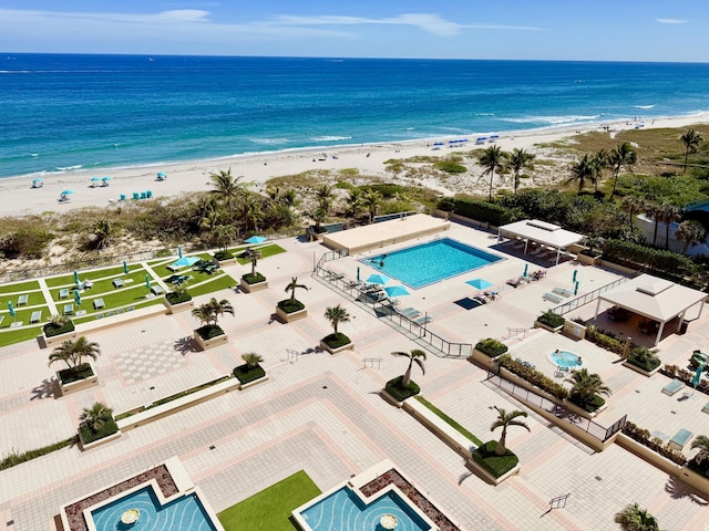 drone / aerial view with a water view and a beach view