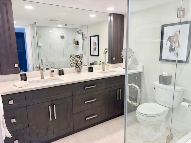 bathroom featuring double vanity, a marble finish shower, toilet, a sink, and recessed lighting