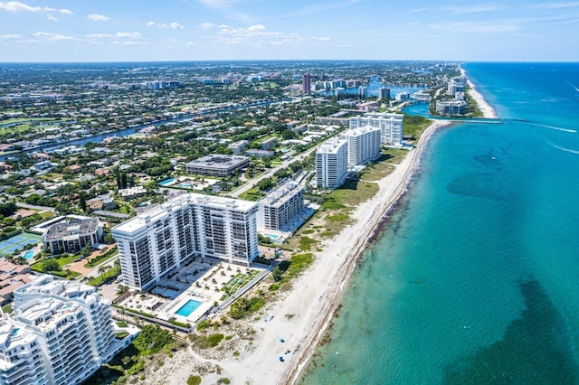 drone / aerial view featuring a water view, a city view, and a view of the beach