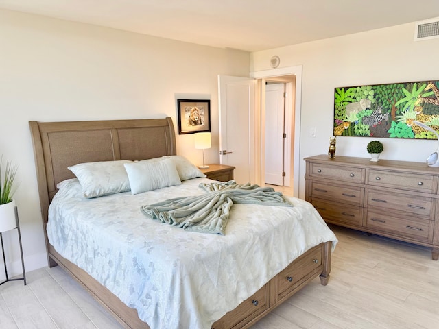 bedroom with visible vents, light wood-style flooring, and baseboards