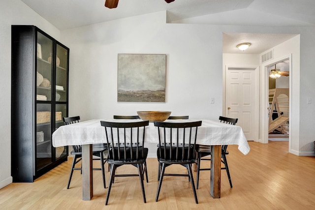 dining area featuring visible vents, lofted ceiling, light wood-type flooring, and a ceiling fan