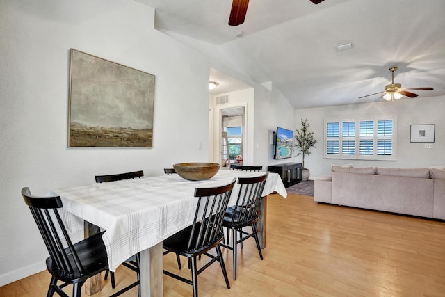 dining space with light wood-type flooring, plenty of natural light, a ceiling fan, and vaulted ceiling