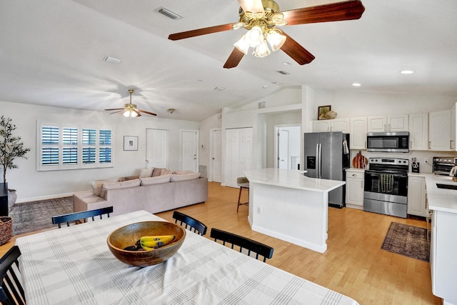 kitchen with a center island, light countertops, appliances with stainless steel finishes, light wood-style floors, and white cabinetry